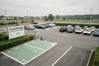 Vue large du parking de covoiturage avec signalisation verte et emplacements réservés au covoiturage près d'une autoroute française
