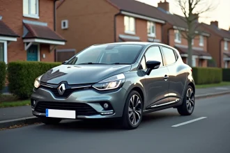 Renault Clio 5 gris métallisé garée dans une rue résidentielle, vue trois quarts avant mettant en valeur son gabarit compact
