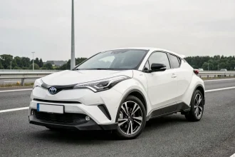Toyota C-HR blanc garé sur une aire d'autoroute française vue en angle 3/4 avant